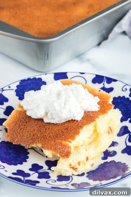 Close-up shot of a slice of Lemon Pudding Cake, highlighting the creamy base and fluffy top.