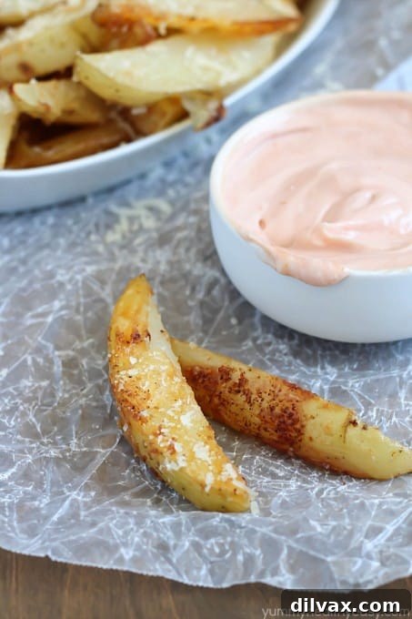 Crispy oven-baked potato wedges generously coated with savory Parmesan cheese and seasonings.
