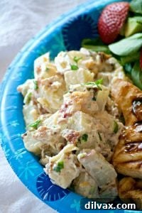 A hearty red potato salad loaded with bacon, green onions, cheese, and a creamy Dijon-mayo dressing.