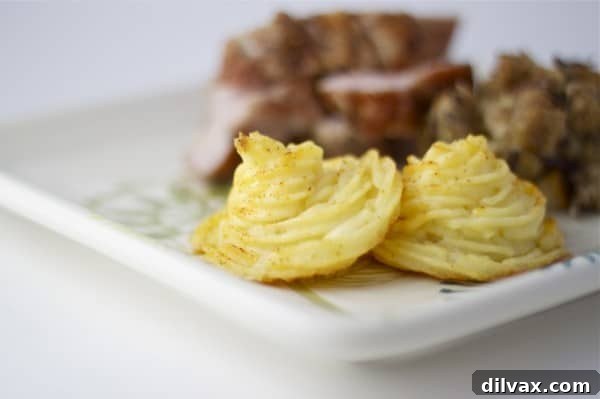 Gorgeous cheddar duchess potatoes baked to a golden finish, promising a taste as exquisite as their appearance.