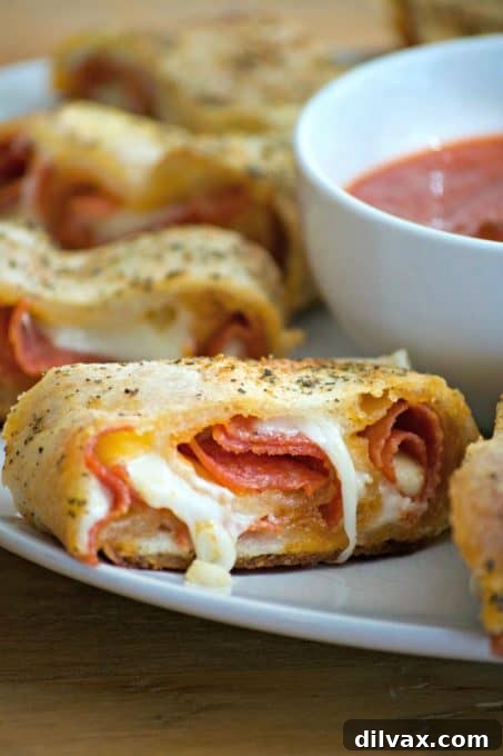 Close-up of a generous slice of pepperoni bread, showcasing the rich layers of pepperoni and melted provolone cheese within the flaky crust.