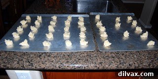 Dropping small portions of cookie dough onto a baking sheet