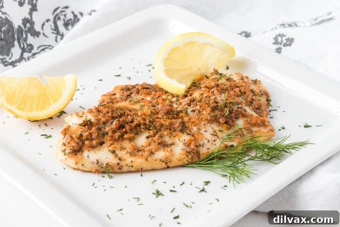Freshly steamed tilapia fillet, garnished with lemon slices and fresh dill, presented in a foil packet.