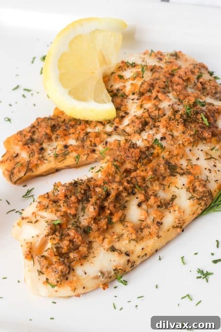 Close-up of a perfectly steamed tilapia fillet, flaked with a fork, ready to be served.