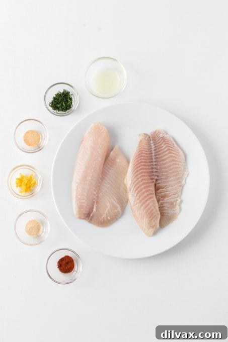 All the fresh ingredients for Steamed Lemon Herb Tilapia laid out on a cutting board.
