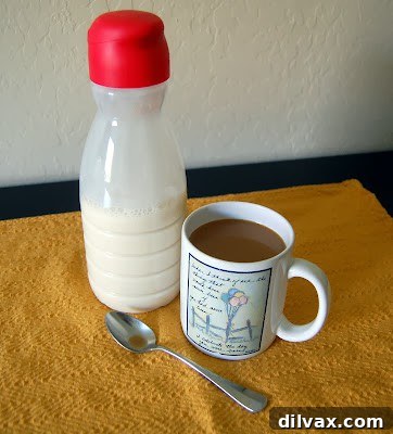 Homemade French Vanilla Coffee Creamer in a glass bottle with coffee cup