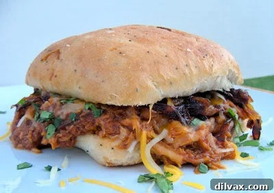 Crockpot BBQ Root Beer Shredded Chicken Sandwiches, piled high with tender chicken and toppings.