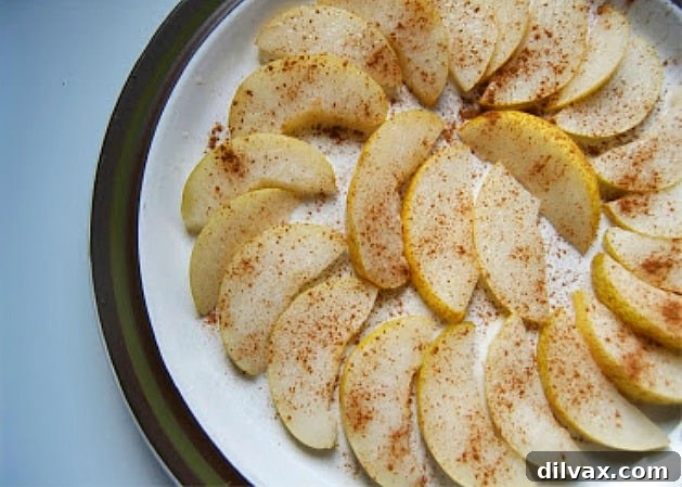Freshly sliced pears and apples dusted with cinnamon, a healthy and fragrant snack.