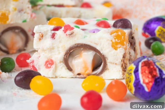 Colorful Easter Fudge 2 Delicious Easter Fudge decorated with mini Cadbury Creme Eggs and colorful Starburst Jelly Beans, ready to be served at a holiday celebration.