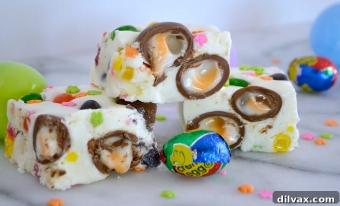 Colorful Easter Fudge 11 A vibrant close-up of Easter Fudge, showcasing the rich white chocolate base studded with mini Cadbury Creme Eggs and Starburst Jelly Beans, ideal for Easter baskets.
