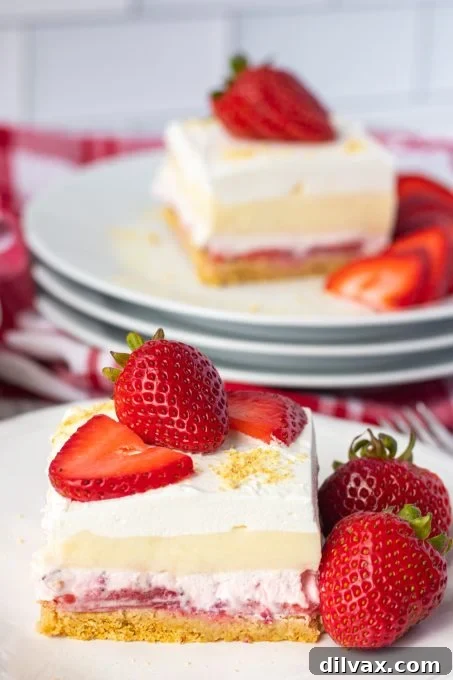 Stacked Strawberry Cheesecake Dream Bars, showing layers of crust, fruit, and cream