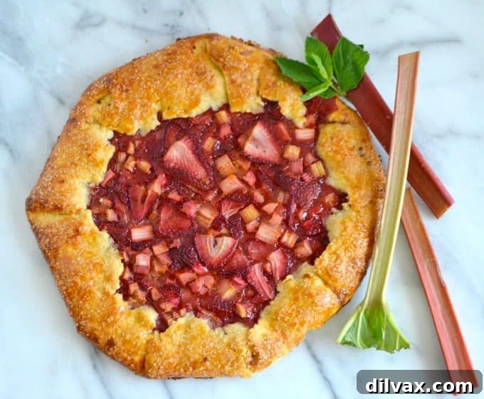 Golden-Crusted Strawberry Rhubarb Bliss 2 A beautifully rustic Strawberry Rhubarb Galette with a golden, flaky crust and bubbly fruit filling, presented on a wooden board.