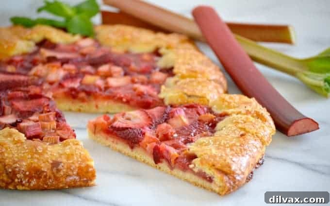 Golden-Crusted Strawberry Rhubarb Bliss 6 A whole Strawberry Rhubarb Galette on a baking sheet, showcasing its perfectly golden, folded crust and bubbly filling.