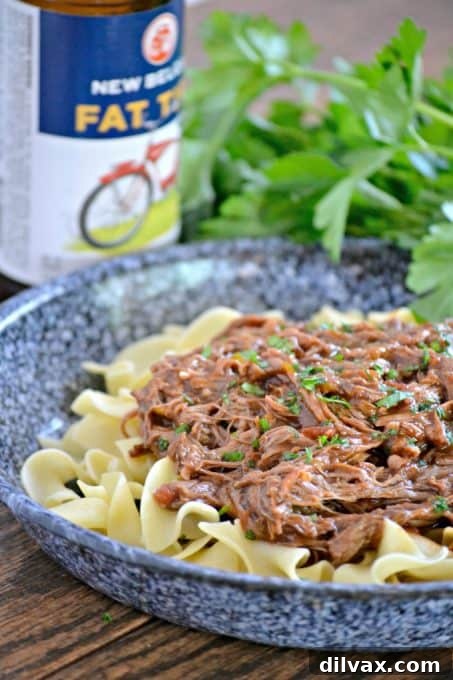 Close-up of tender, shredded beef pot roast in a slow cooker