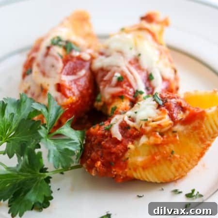 Pepperoni Pizza Stuffed Shells are pasta shells stuffed with ricotta and Parmesan cheese, diced pepperoni, and topped with pizza sauce.