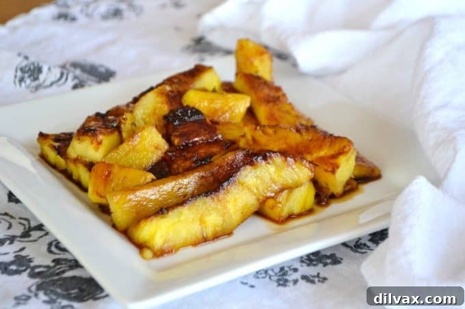 Rum-soaked grilled pineapple coated in brown sugar, served as a simple dessert or ice cream topping.