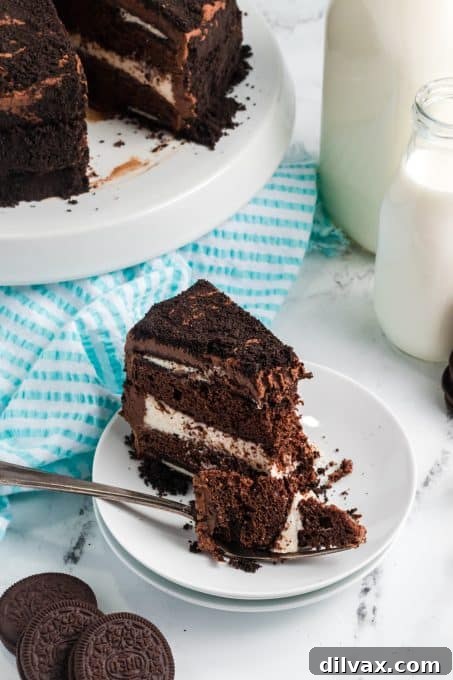 Decadent Oreo Dream Cake 6 A delicious bite taken out of a slice of Oreo Cake, highlighting its moist texture and visible Oreo pieces.
