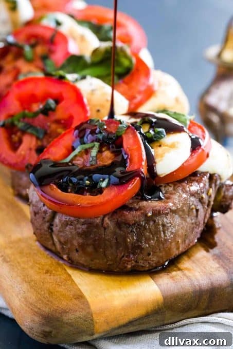 Elegant Caprese Grilled Filet Mignon, topped with fresh mozzarella, basil, and tomato.