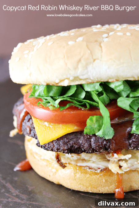 Copycat Red Robin Whiskey River BBQ Burger, dripping with sauce and toppings.