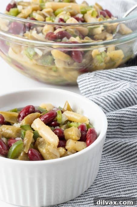 An easy summertime salad featuring a mix of beans, green bell pepper, and red onion.