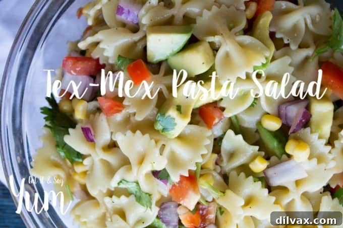 A vibrant Tex-Mex Pasta Salad in a bowl, featuring colorful vegetables, black beans, corn, and pasta, all tossed in a zesty lime cilantro dressing.