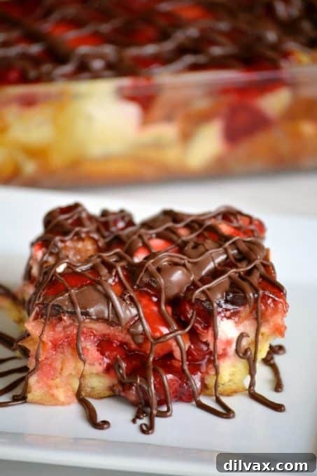 Another perspective of the rich Chocolate Cherry Cheesecake Bread Pudding, showcasing the depth of the cherry filling, the golden texture of the bread, and the glossy chocolate drizzle, inviting a taste.