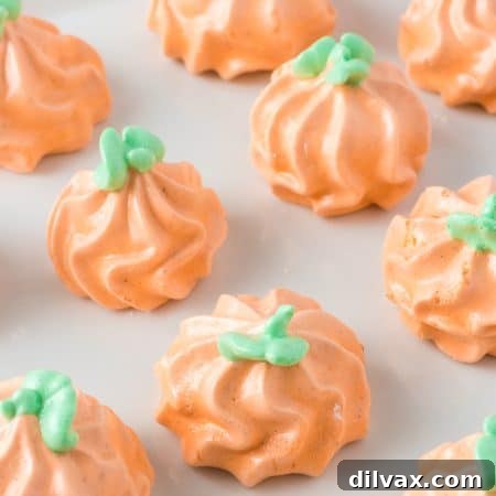 Green stems and leaves decorate pumpkins made of meringue.
