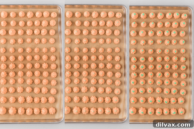 Process photo showing a baking sheet full of piped Pumpkin Spice Meringue Pumpkins ready for the oven