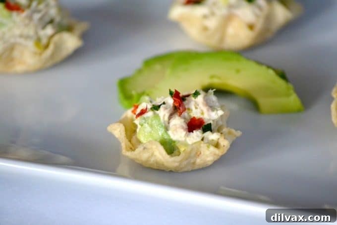 Avocado Tuna Delights 2 These Avocado Tuna Salad Bites, sprinkled with chives and chili pepper flakes, are the perfect addition to your party or Game Day menu, offering a delightful kick.
