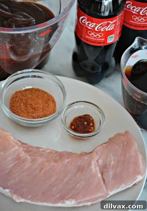 Sweet Heat Cola Pulled Pork Bites 6 A close-up of a seasoned pork loin, ready for the slow cooker, rubbed with a dry spice blend and chili paste.