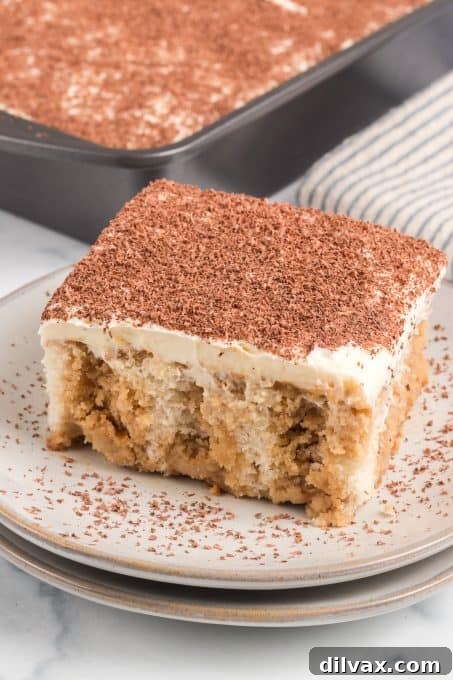 White Poke cake with coffee syrup and mascarpone frosting, garnished with chocolate shavings