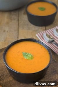 A steaming bowl of comforting 30 Minute Tomato Basil Soup, garnished with fresh basil leaves.