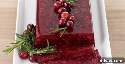 Jellied cranberry sauce with Fuji apples, served in a decorative bowl.