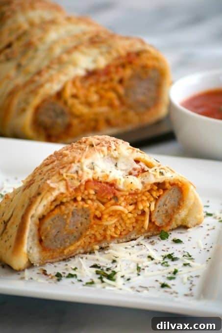Braided Spaghetti and Meatball Bake 3 A beautifully presented Spaghetti and Meatball Braid on a cutting board, showcasing the golden-baked crust and the rich filling visible from a slice.