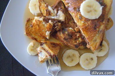 A close-up of a stack of Banana Nutella Stuffed French Toast slices, revealing the gooey Nutella and banana filling.