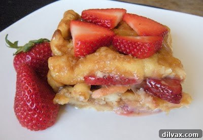 Fluffy golden baked strawberry waffles, topped with fresh strawberries and syrup.