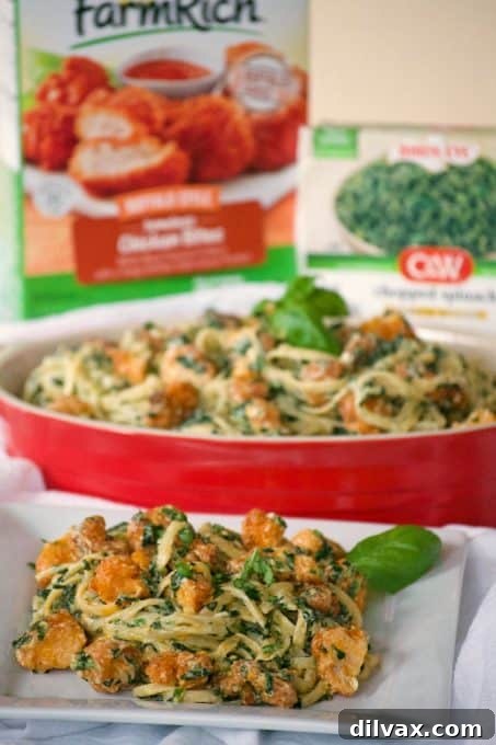 Close-up of creamy Buffalo Chicken Spinach Alfredo pasta, showing the rich sauce, chicken pieces, and visible spinach flecks. An ultimate easy family dinner.