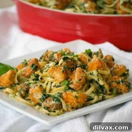 Buffalo Chicken Spinach Alfredo in a white bowl with a fork.
