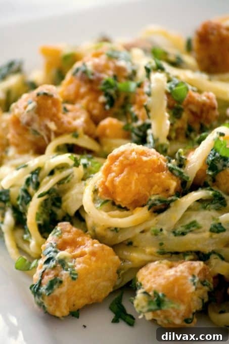 Another perspective of the Buffalo Chicken Spinach Alfredo pasta in a bowl, highlighting its sauciness and vibrant ingredients. A quick and satisfying meal option.