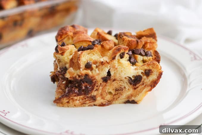 A beautifully plated slice of Chocolate Croissant Baked French Toast, dusted with powdered sugar.