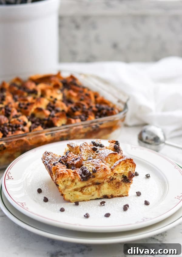 A slice of Chocolate Croissant Baked French Toast, beautifully dusted with powdered sugar, ready to be picked up.