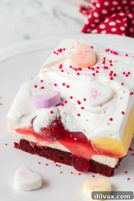 A beautifully presented red velvet dessert with cherries, cheesecake and vanilla pudding.