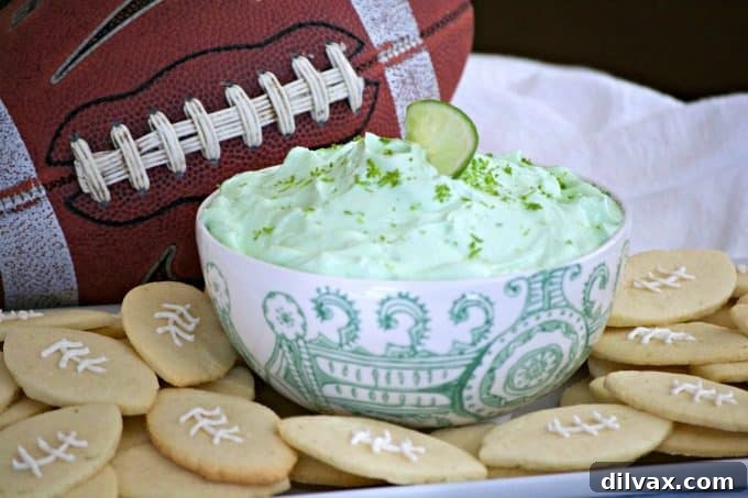 This Lime Cheesecake Dip made with cream cheese, confectioners' sugar, Shamrock Farms sour cream, lime juice and gelatin pairs perfectly with Football Sugar Cookies and some fresh fruit. It's the perfect Game Day treat and you'll be voted MVP!