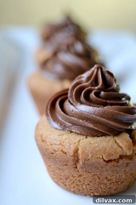 Peanut Butter Cookie Cups stuffed with a mini Reese's and topped with chocolate buttercream!