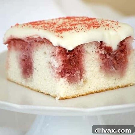 Finished Strawberry Poke Cake with creamy frosting and red sprinkles, ready to be served.