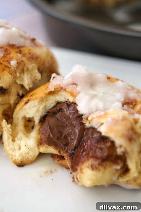 A close-up of a warm Nutella cinnamon roll with melted icing, perfect for a cozy morning