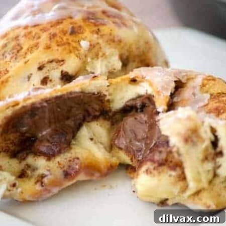A perfectly baked Nutella cinnamon roll, glazed and ready to eat