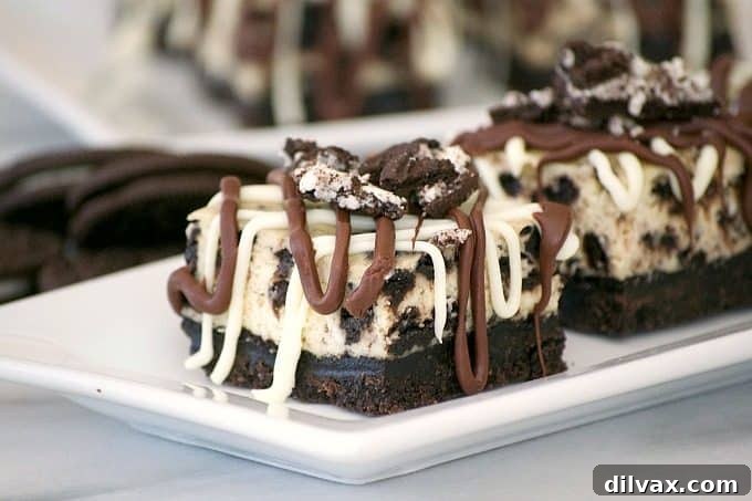 Everyone will love these Cookies and Cream Cheesecake Bars with their Oreo cookie crust, cookies and cream cheesecake layer and drizzled with chocolate.