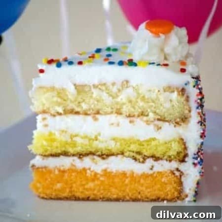 Sunshine Citrus Cake 7 A beautifully decorated slice of Citrus Layer Cake with visible layers of vanilla, lemon, and orange, topped with frosting and sprinkles.