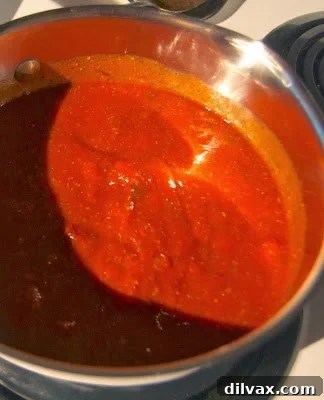 Homemade Pizza Sauce Perfection 2 A bowl of rich, red homemade pizza sauce garnished with fresh basil leaves.